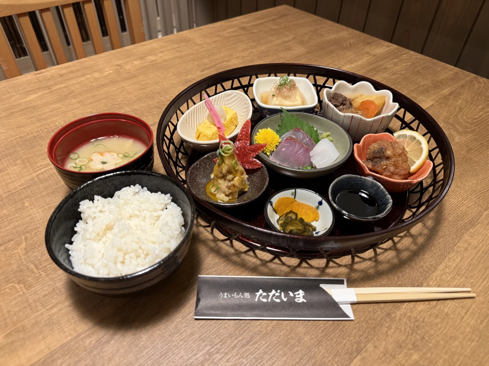 刺身や小鉢を籠に盛り、ご飯と汁物を添えたお食事